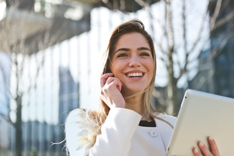 pexels-photo-789822-789822 Confident businesswoman using her tablet and phone, smiling outdoors in sunlight.